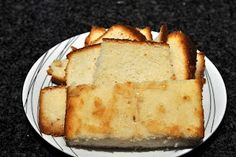 slices of bread on a white plate sitting on a black counter top with the rest of it cut in half