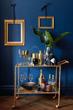 an article in the interior design magazine about go for gold, with wine glasses and bottles on a bar cart