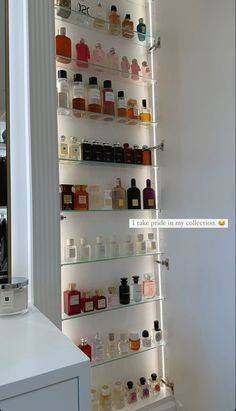 the shelves in this bathroom are filled with different types of bottles and containers, all lined up against each other