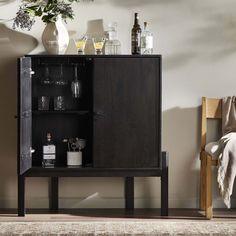 a black cabinet with bottles and glasses on it