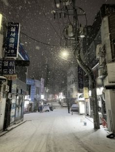 a snow covered street with people walking on it