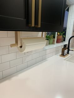 a kitchen counter with a roll of toilet paper hanging from it's holder above the sink