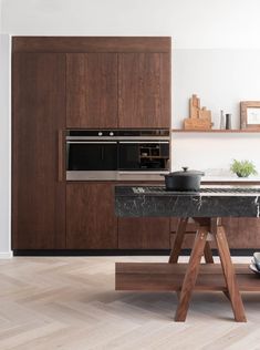 a kitchen with marble counter tops and wooden cabinets, along with an oven in the center