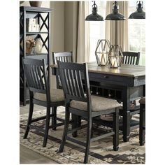 a dining room table and chairs with an area rug on the floor next to it