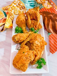 fried chicken on a white plate with parsley