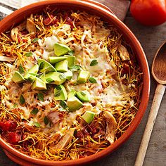 an orange bowl filled with shredded cheese, avocado and tomatoes