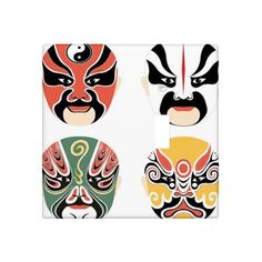 three masks on a light switch plate with different colors and designs, one is red, the other is green