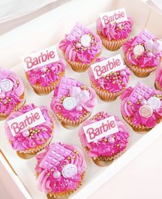 cupcakes with pink frosting and decorations in a white box that says barbie