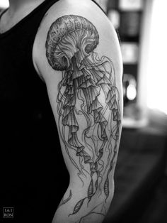 a black and white photo of a woman's arm with a jellyfish tattoo on it