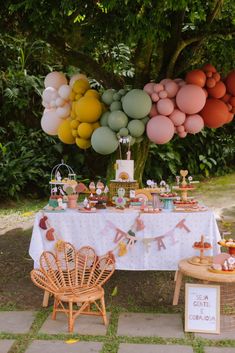 a table topped with lots of balloons and desserts