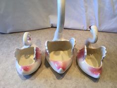 three white swan shaped bowls sitting on top of a table