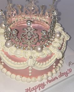 a pink and white cake with a tiara on top