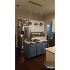 a kitchen with white cabinets and blue island