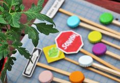 there are many different colored candies on the table next to a potted plant