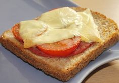 a close up of a sandwich with cheese and tomatoes