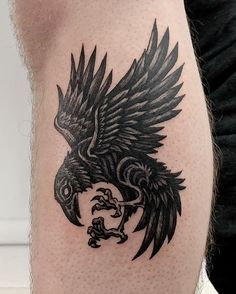 a black and white tattoo on the leg of a man with an eagle in it's claws