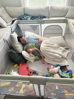 a man laying in a crib with his baby