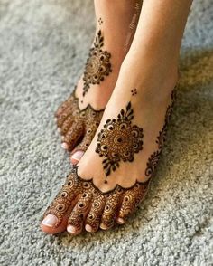 the feet are decorated with henna and flower designs on it's toes, which is