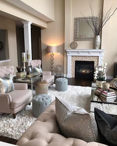 a living room filled with furniture and a fire place in front of a mirror on the wall