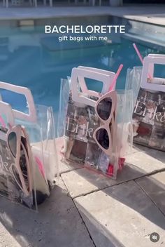 three bags with sunglasses on them sitting next to a swimming pool