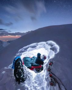 two people are sitting in the snow at night