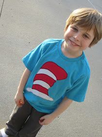 a young boy wearing a cat in the hat t - shirt standing on a skateboard