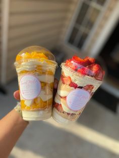 two plastic cups filled with fruit sitting next to each other in front of a house