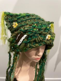 a mannequin head wearing a green hat with flowers on it