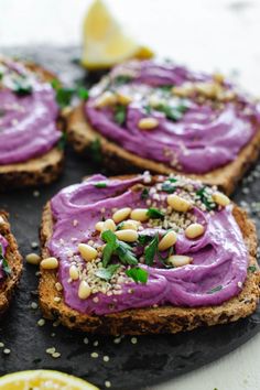 purple hummus on toast with lemon wedges and parsley