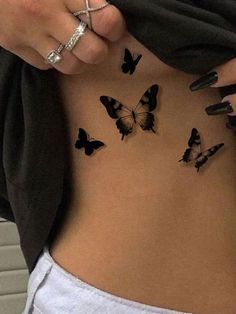 a woman's stomach with butterflies on the side and her hand holding onto it