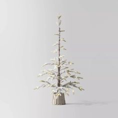 a small white christmas tree in a wicker basket