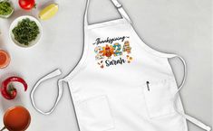 an apron with the words thanksgiving written on it next to bowls of vegetables and sauces