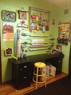 a room with green walls and lots of things on the wall, including a yellow stool