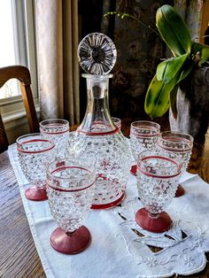 an old fashioned decanter and six wine glasses on a table