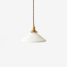 a white and gold pendant light hanging from a cord