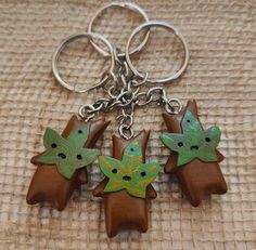 three brown and green plastic toy animals on a metal keychain with two smaller ones in the middle