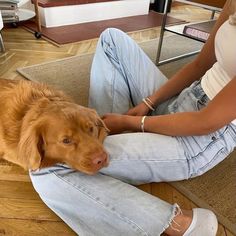 a woman sitting on the floor with her dog