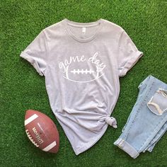 Game Day with football graphic on front of t-shirt. Graphic color varies on t-shirts. Adult Sizes S-XXL (unisex sizing)Youth Sizes S-XL (unisex sizing) For Game Day Sweatshirts click here to view.Bella + Canvas4.2 oz. Airlume combed and ring-spun cottonPre-shrunkFor a more relaxed fit, size up! Game Day Football Season Graphic Tee, Football Season Graphic Tee T-shirt, Graphic Tee T-shirt For Football Season With Screen Print, Graphic Tee With Screen Print For Football Season, Graphic Tee T-shirt For Football Season, Graphic Tee T-shirt With Screen Print For Football Season, Pre-shrunk Graphic Tee For Football Season, Game Day Graphic Tee With Slogan, Game Day Slogan Graphic Tee