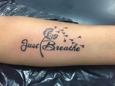 a tattoo with the words just breathe on it and a dandelion flying in the air