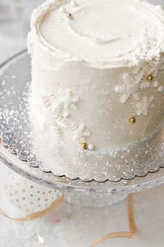 a white frosted cake sitting on top of a glass plate