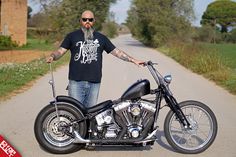 a man standing next to a motorcycle on a road