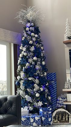 a blue christmas tree with silver and white ornaments