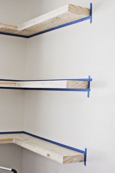 three shelves with blue tape on them in a room