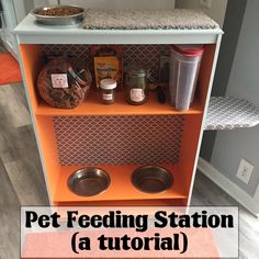 an orange pet feeding station with bowls and food