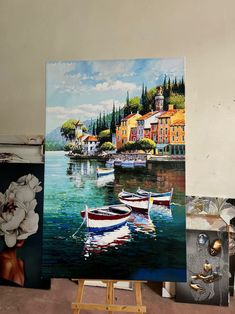 there are three paintings on easels with one painting of boats in the water and flowers