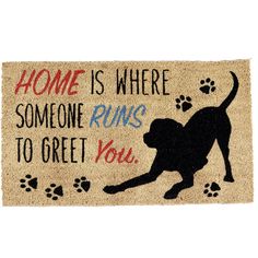 a door mat that says home is where someone runs to greet you with a dog and paw prints