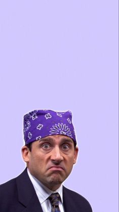 a man in a suit and tie with a purple bandanna on his head looking surprised