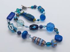 Handmade LAMPWORK MURANO fish necklace with various style glass blue beads, Unique costume jewelry, Murano blue jewellery, Lampwork necklace Gorgeous handmade Murano blue glass necklace with various styled lampwork beads that are each individually handmade. The necklace has a mix of styled art glass that includes cylindrical, squares and round and even a fish that are also hand strung. A beautiful and unique piece of statement handmade jewellery that would be a talking point in any occasion.  Th Blue Jewellery, Lampwork Necklace, Fish Necklace, Unique Costumes, Blue Jewelry, Glass Necklace, Handmade Jewellery, Lampwork Beads, Blue Beads