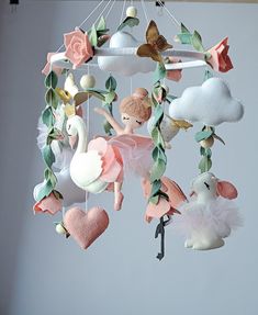 a mobile made out of stuffed animals hanging from a string with leaves and flowers on it