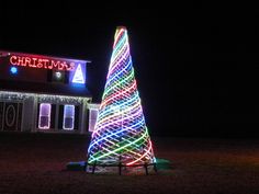 a lighted christmas tree in front of a house